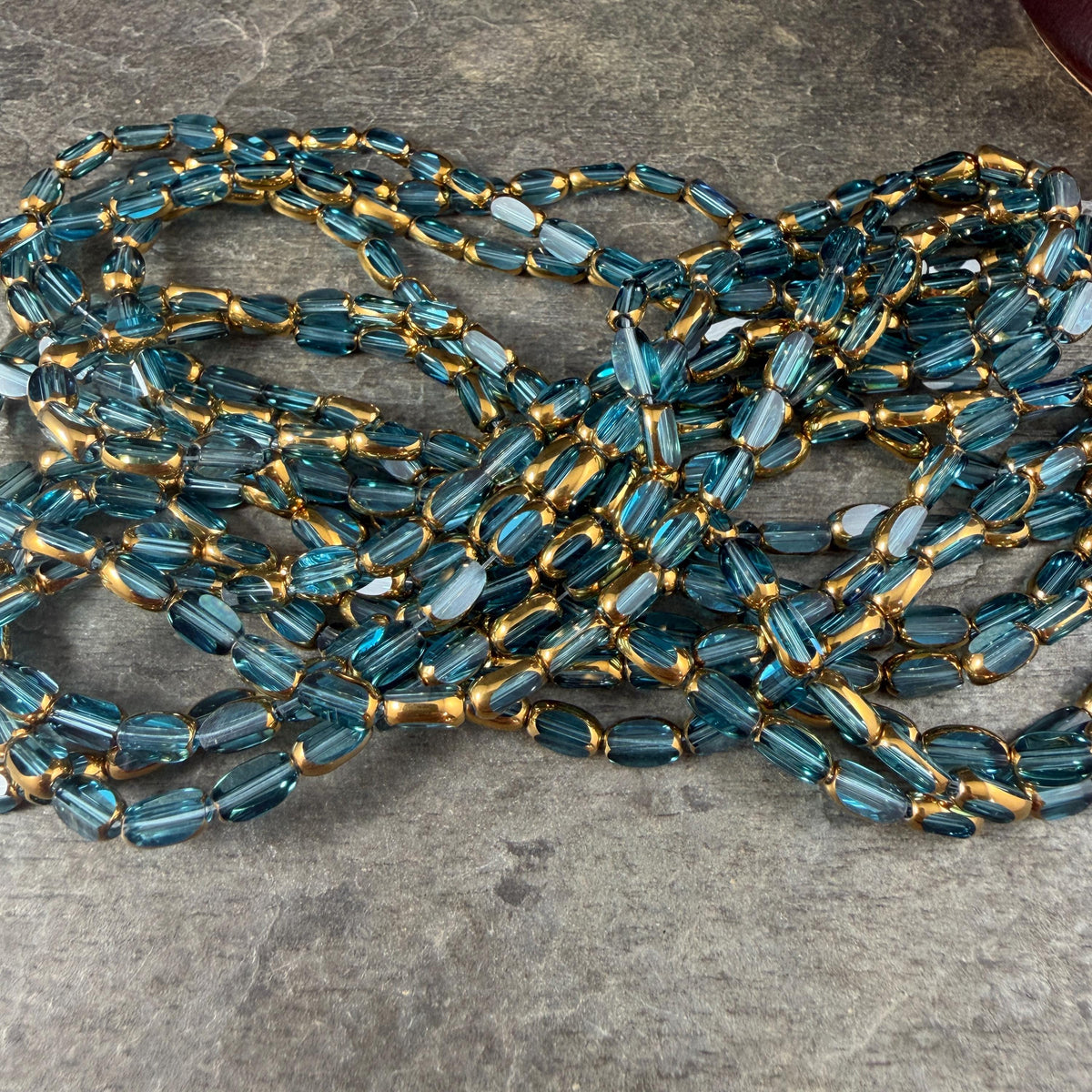 Electroplated Glass Beads - 7x4.5mm Faceted Oval, Transparent Lagoon Blue with Gold Finish (A01-01B) * Qty. 50 Beads